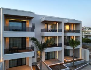 an apartment building with balconies and palm trees at U boutique experience in Alexandroupoli