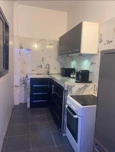 a kitchen with a sink and a stove at Oka in Déni Diarke