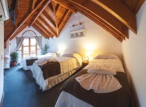 ein Zimmer mit drei Betten und einem Fenster in der Unterkunft Cabañas centricas Rotui Patagonia Group in San Martín de los Andes