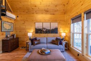 a living room with a blue couch and wooden walls at Retreat at Riverbend in West Jefferson