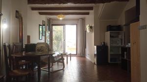 een eetkamer met een tafel en stoelen en een raam bij Studio privé - maison de village in Valensole