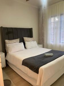 a large bed in a bedroom with a large window at Blissful Breeze in Richards Bay +15 photos