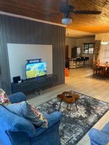 a living room with a blue couch and a flat screen tv at Blissful Breeze in Richards Bay +14 photos