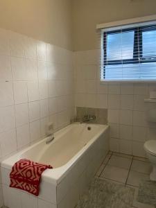 a white bathroom with a tub and a toilet at Blissful Breeze in Richards Bay