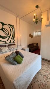 a bedroom with a white bed with a green pillow at Casa Sete Mares in Guarujá