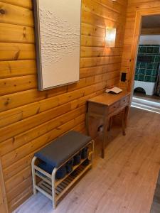 a room with a wooden wall with a bench and a table at Ruhige Hütte mit toller Aussicht in Dammbach