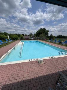 Una gran piscina con sillas azules y un cielo azul en Lóyly Spa Guesthouse, en Ottawa