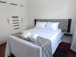 a bedroom with a white bed with towels on a table at Plaza Independencia in Mendoza