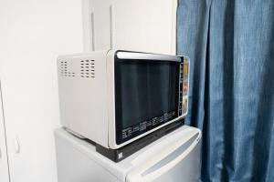 a microwave sitting on top of a toilet at 御嶽ハウス in Tokyo