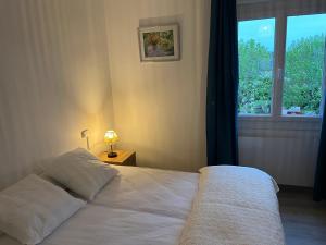a bedroom with a white bed and a window at Aux Primevères in Saint-Honoré-les-Bains