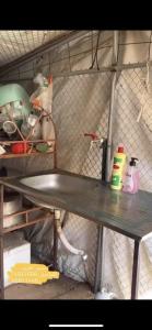 a shelf in a kitchen with a metal table at قريه الواصل in Shāhiq