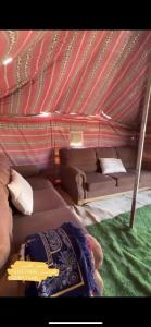 a room with a couch and a bed with a guitar at قريه الواصل in Shāhiq