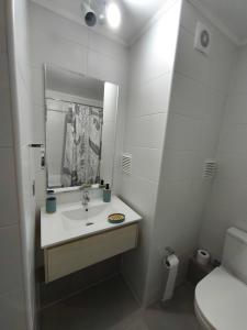 a white bathroom with a sink and a toilet at Departamento amoblado in San Pedro de la Paz