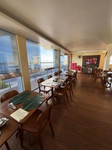 a restaurant with wooden tables and chairs and a balcony at Sumaúma Hotel in Tefé