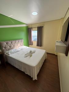 a bedroom with a bed with a flower on it at Sumaúma Hotel in Tefé