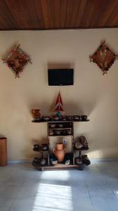 a room with a tv on a wall at QUARTO PARA 3 PESSOAS em SÃO BRAZ, banheiro compartilhado in Belém