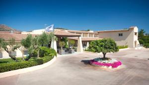 a tree in a flower bed in a courtyard at Hotel San Teodoro in San Teodoro