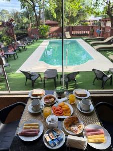 una mesa con platos de comida junto a una piscina en Terra Iguazú Suites, en Puerto Iguazú 13 fotos más