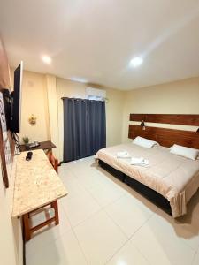 Un dormitorio con una cama y un televisor. en Terra Iguazú Suites, en Puerto Iguazú