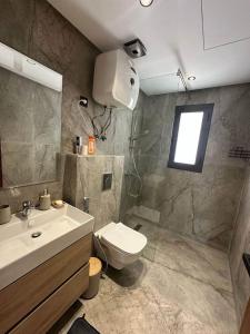 a bathroom with a sink and a toilet and a shower at Résidence al BASSLAM agadir in Agadir