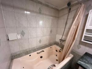 a bathroom with a bath tub with a shower curtain at F&F alojamiento in Punta del Este +13 photos