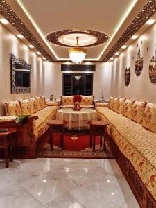a large living room with couches and a table at Résidence al BASSLAM agadir in Agadir