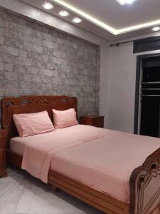 a bedroom with a large bed with pink pillows at Résidence al BASSLAM agadir in Agadir