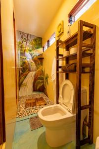 a bathroom with a toilet and a mural at La Maison - Siquijor in Siquijor +53 photos