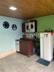 una cocina con estufa y refrigerador en Quarto privativo,não é compartilhado!, en Parauapebas