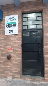 a building with a black door and a sign on it at Studio Home in Jacareí