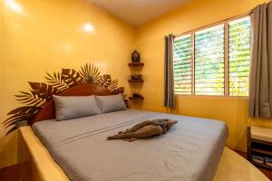 a teddy bear laying on a bed in a room at La Maison - Siquijor in Siquijor