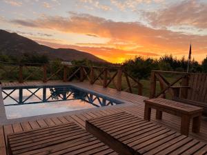 a pool on a deck with a sunset in the background at Casa Lolol Colchagua in Rincón de Ubilla
