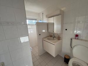 a white bathroom with a toilet and a sink at Bed & Boerderij  +12 photos
