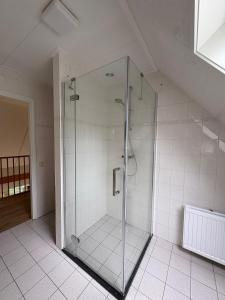 a glass shower stall in a white bathroom at Bed & Boerderij 