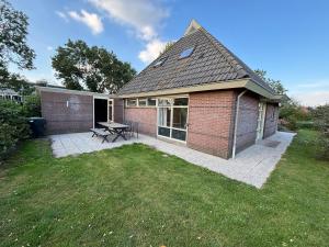 a brick house with a picnic table in a yard at Bed & Boerderij 