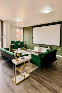 a living room with green furniture and a large screen at Cinema Lounge 2Bed Leeds City Centre FREE Parking in Leeds
