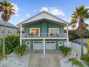 a house on the beach with palm trees at Aqua Vista l Beach Views I Pool Spa in Butler Beach