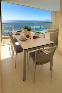 アルテアにあるCosta Blanca Sea Viewのダイニングテーブル、海の景色を望む椅子