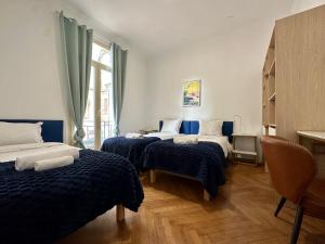 Zimmer mit 3 Betten mit blauer und weißer Bettwäsche in der Unterkunft Villa Clair LOGIS MONACO Parking Terrasse in Beausoleil