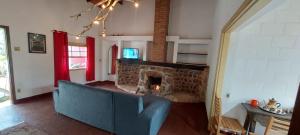 a living room with a blue couch and a fireplace at Parque Paraíso das Flores in Holambra