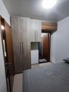 a bedroom with a bed and wooden cabinets at Estrela Da Manhã Flat in Brasilia