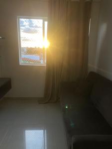 a living room with a couch and a window at Estrela Da Manhã Flat in Brasilia