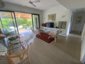 a living room with a glass table and chairs at AZURI Serviced Garden Apartment in Roches Noires