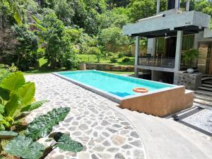 una piscina en un patio al lado de una casa en Mindara Villa, en Galle