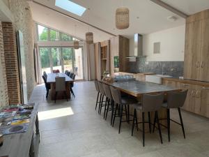 een keuken met een grote houten tafel en stoelen bij Le Moulin des Etrebières in Cheffois