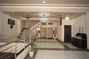 a lobby with a staircase and a chandelier at Nidhipataye Homestay in Shivāpur