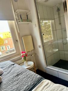 a bedroom with a bed and a glass shower at Eastern in Tilburg