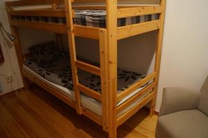 a wooden bunk bed in a room with a couch at Laplanders room 2 in Kiruna