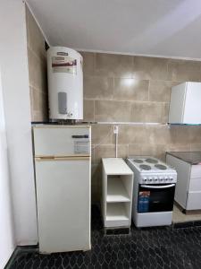 a small kitchen with a refrigerator and a stove at Marlu house in San Nicolás de los Arroyos