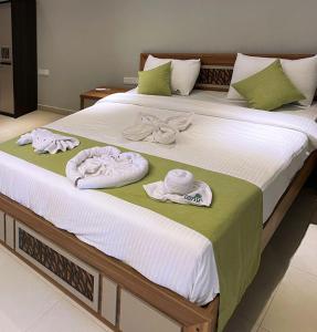 uma cama com toalhas e chapéus em cima em Odyssey Boutique Hotel em Baía de Arugam